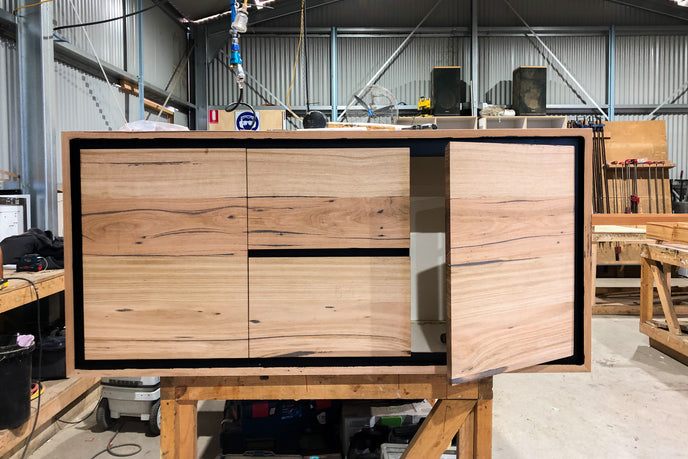 Timber wall hung vanity with black features, drawer and cupboards