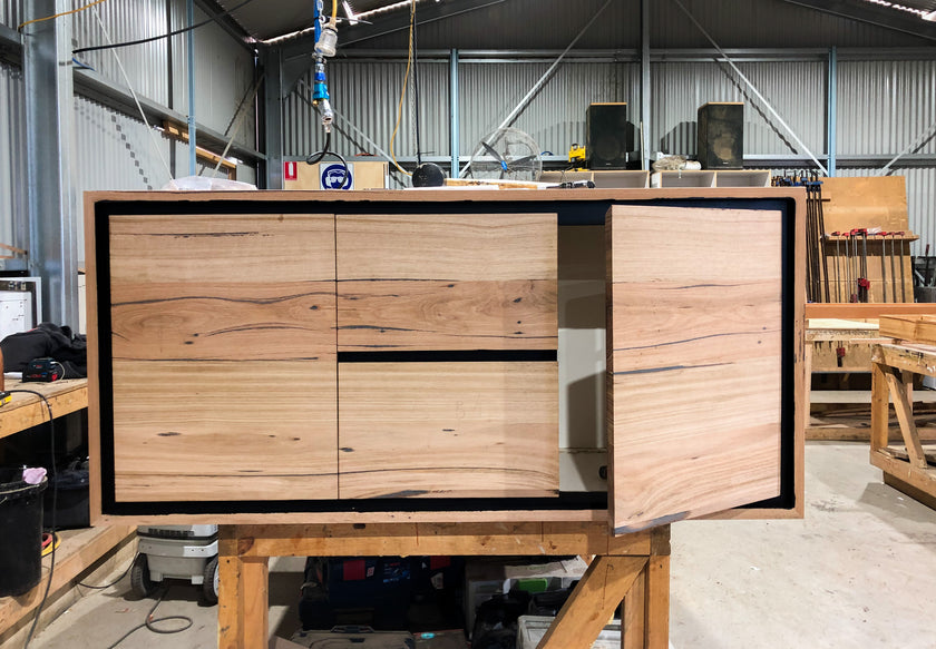 Timber wall hung vanity with black features, drawer and cupboards